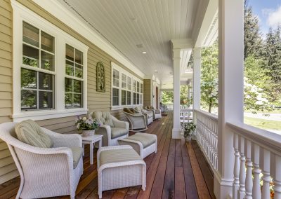Long front porch with chairs and ottomans